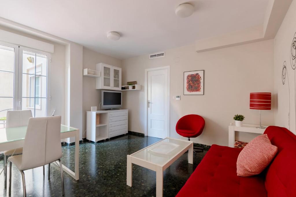 ein Wohnzimmer mit einem roten Sofa und einem Tisch in der Unterkunft Apartamento valencia centro in Valencia