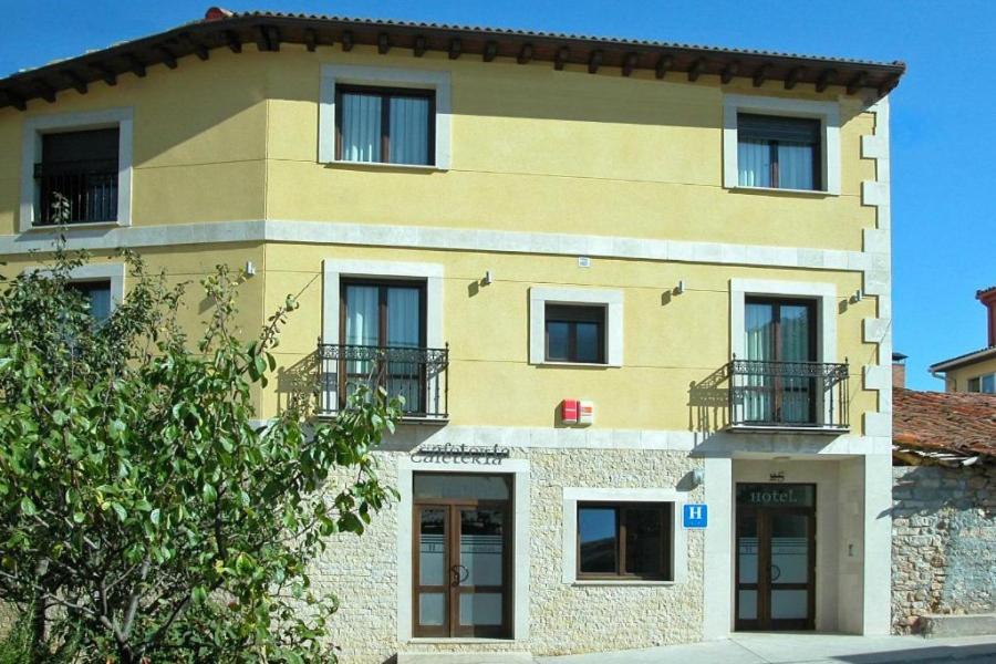 a large yellow building with windows and balconies at Hotel Brezales in Espejón