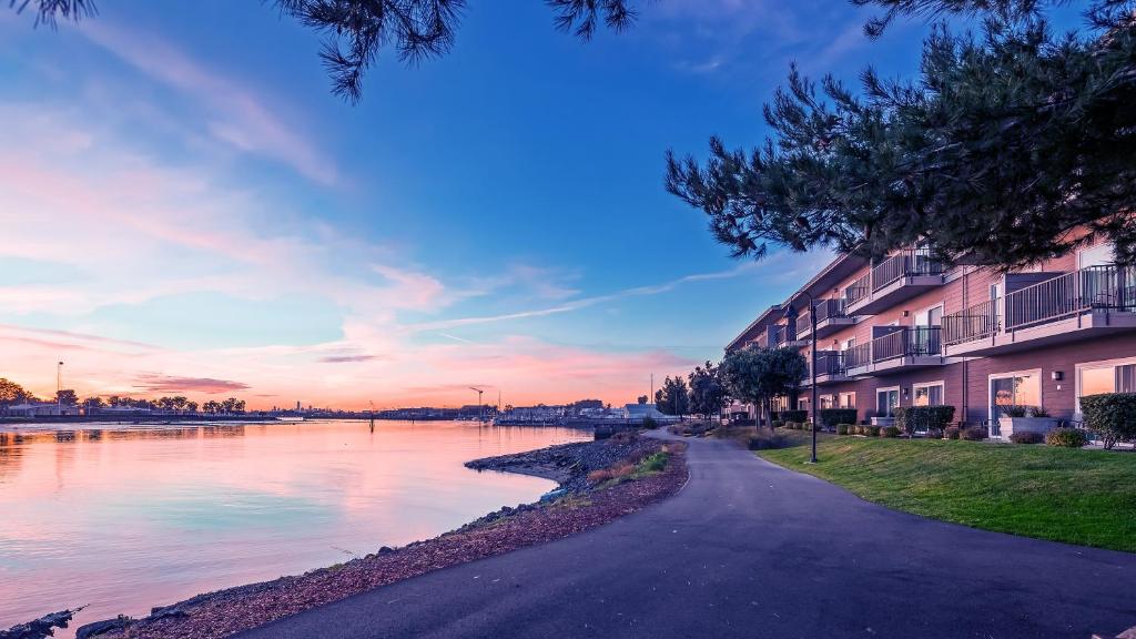 - une vue sur une rivière au coucher du soleil avec des bâtiments dans l'établissement Executive Inn & Suites Oakland, à Oakland