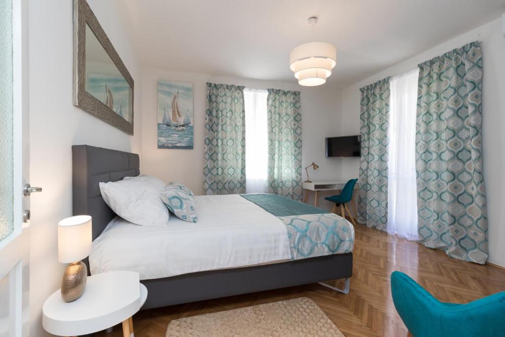 ザダルにあるDeluxe suite Navisのベッドルーム1室(ベッド1台、青い椅子付)