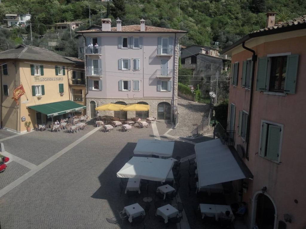 an aerial view of a building with tables and umbrellas at Appartamenti Menapace in Torri del Benaco