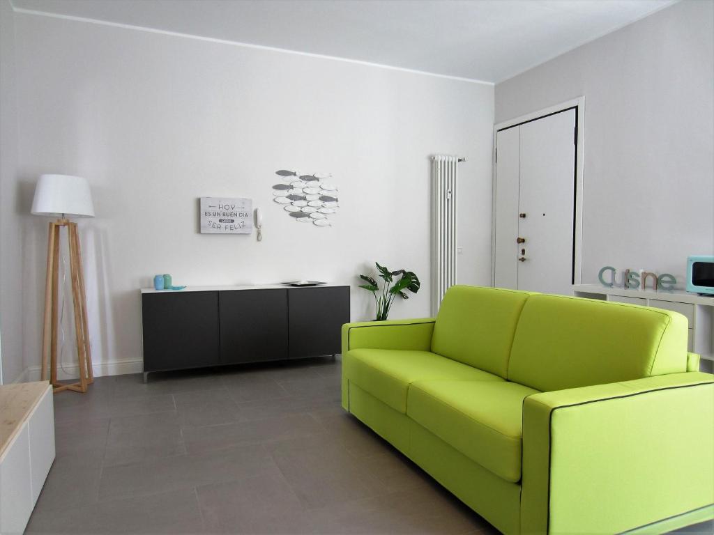 a living room with a green couch and a table at New & modern apartment on the sea in Rimini