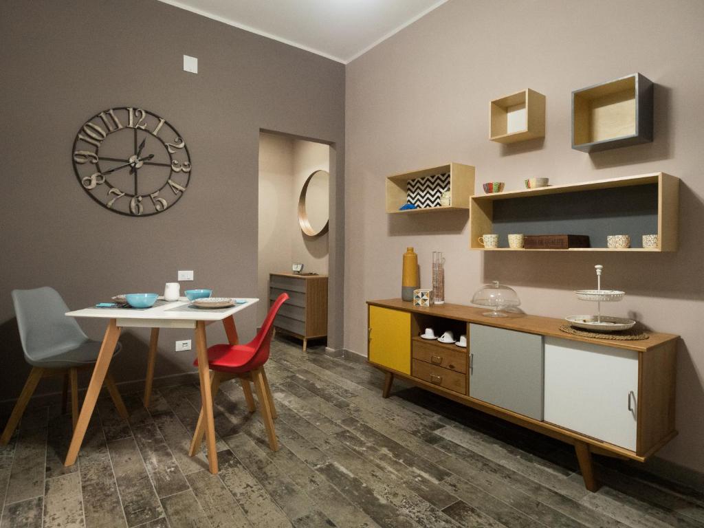 comedor con mesa y reloj en la pared en Appartamento in villa en Caltanissetta