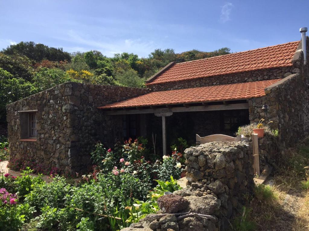 a stone house with a stone wall and a garden at El Pajero de Erese in Erese