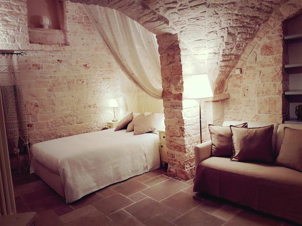 sypialnia z 2 łóżkami i kanapą w obiekcie Trulli D'Angiò w Alberobello