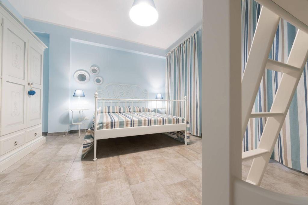 Lido ConchigliaにあるCasa Vacanze Anfitriteの白いベビーベッドと青い壁が備わる子供用ベッドルーム1室