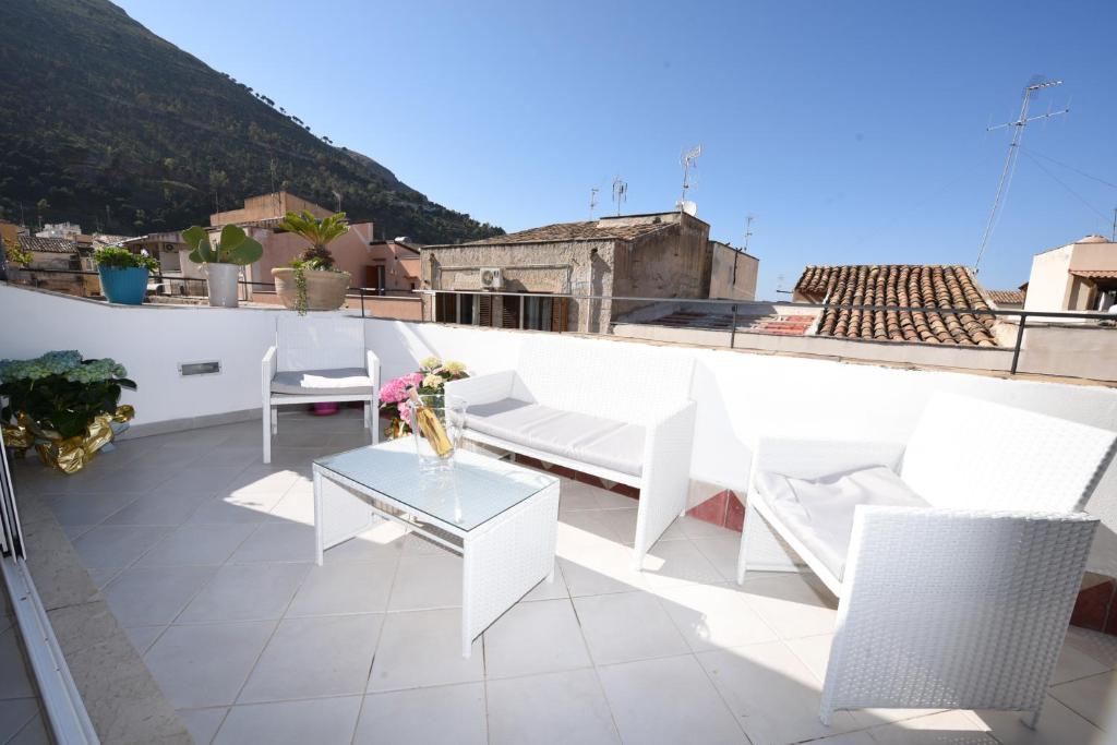 a balcony with a table and chairs on a roof at Terrazza in Palazzo Taormina in Castellammare del Golfo