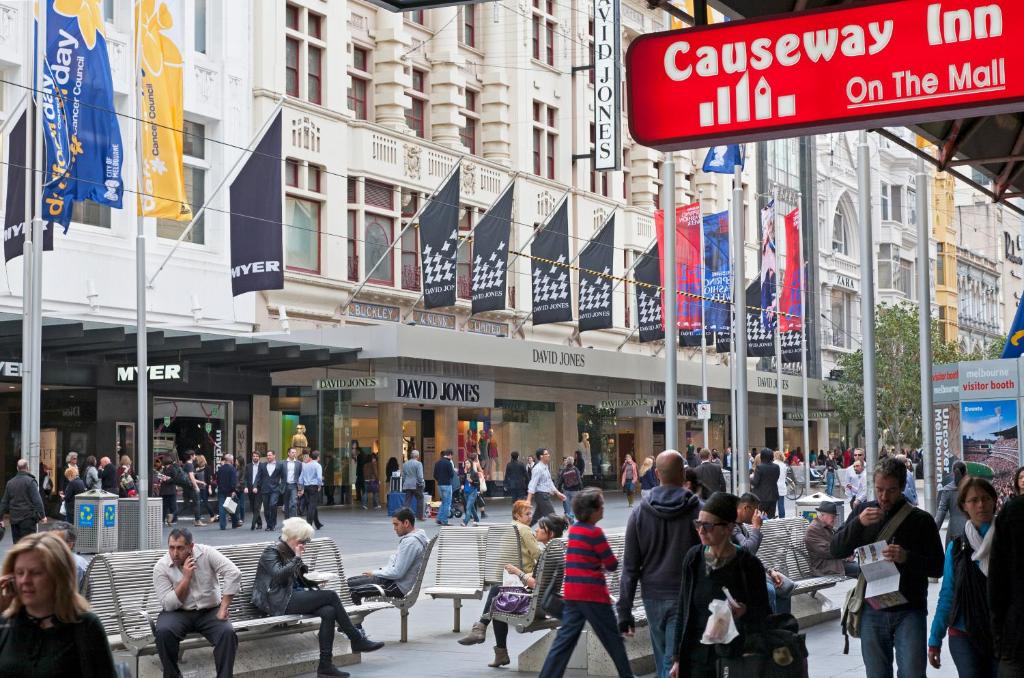 a crowd of people walking on a busy city street at Causeway Inn On The Mall in Melbourne