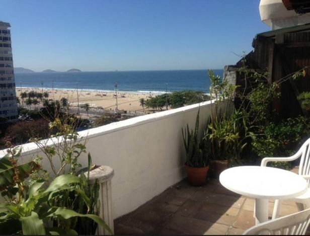 balcón con mesa y vistas a la playa en Apartamentos Copacabana ampla vista mar, en Río de Janeiro
