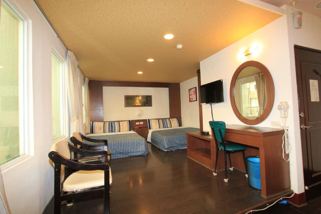 a living room with a desk and a mirror at HC Inn in Hengchun