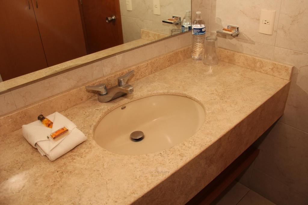 encimera con fregadero y toalla en Hotel Real Zapopan, en Guadalajara