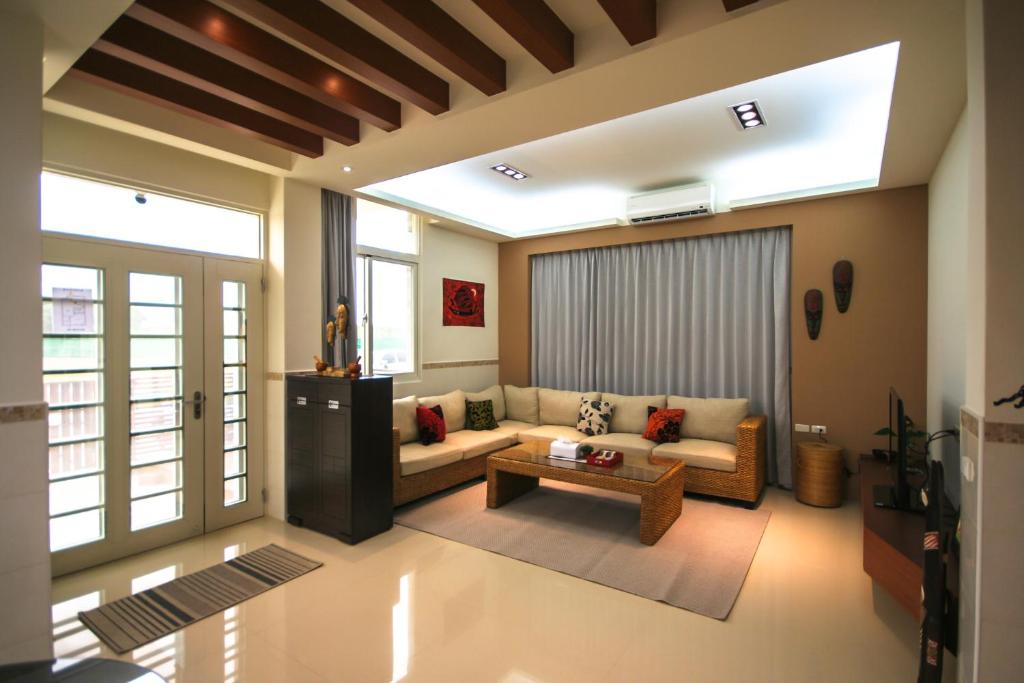 sala de estar con sofá y mesa en 晴光部落-包棟民宿10-12位近山水沙灘, en Magong