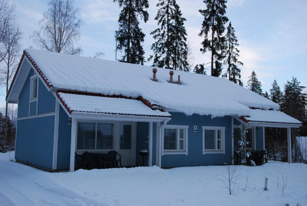 una casa azul con nieve encima en Spa Suites Ikaalisten Kylpylä, en Ikaalinen