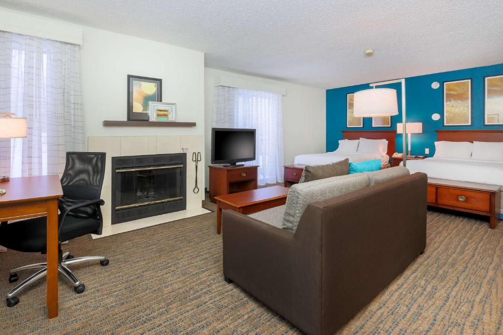 a hotel room with a couch and a bed and a desk at Hawthorn Suites by Wyndham Tinton Falls in Tinton Falls