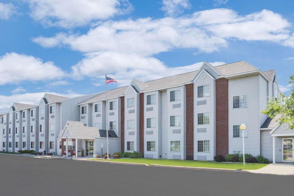 um grande edifício branco com uma bandeira em cima em Microtel Inn & Suites by Wyndham Fond Du Lac em Fond du Lac