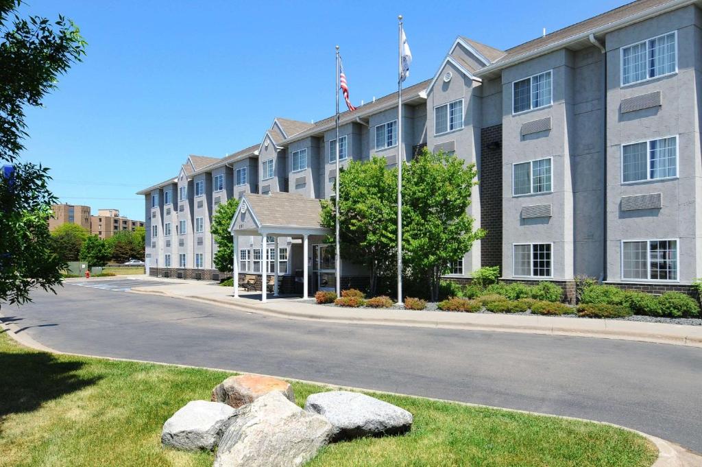 a large building with rocks in front of it at Microtel Inn & Suites by Wyndham Bloomington MSP Airport in Bloomington