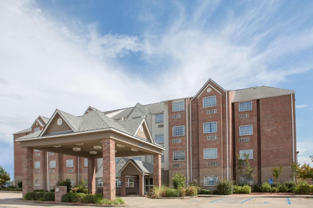 a large brick building with a roof at Microtel Inn & Suites by Wyndham Hattiesburg in Hattiesburg