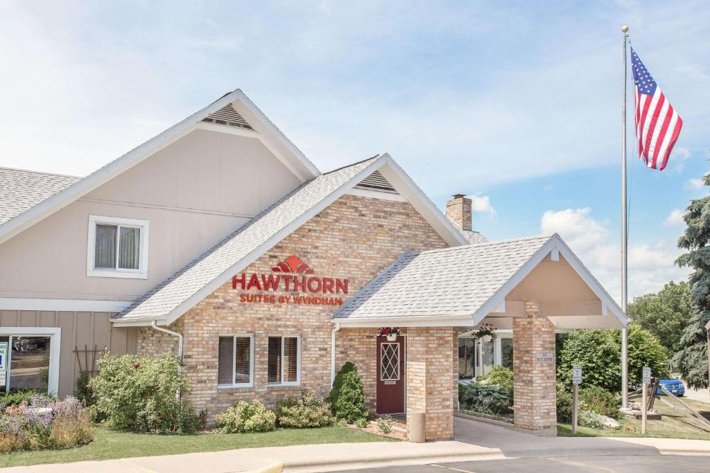 a restaurant with an american flag in front of it at Hawthorn Extended Stay Hotel by Wyndham-Green Bay in Green Bay