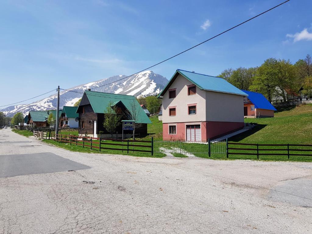 Une rangée de maisons avec des montagnes en arrière-plan dans l'établissement Apartments Đurđić, à Žabljak