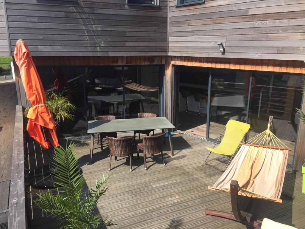 a deck with a table and chairs and a table and chairs at Hôtel des Rochers in Perros-Guirec