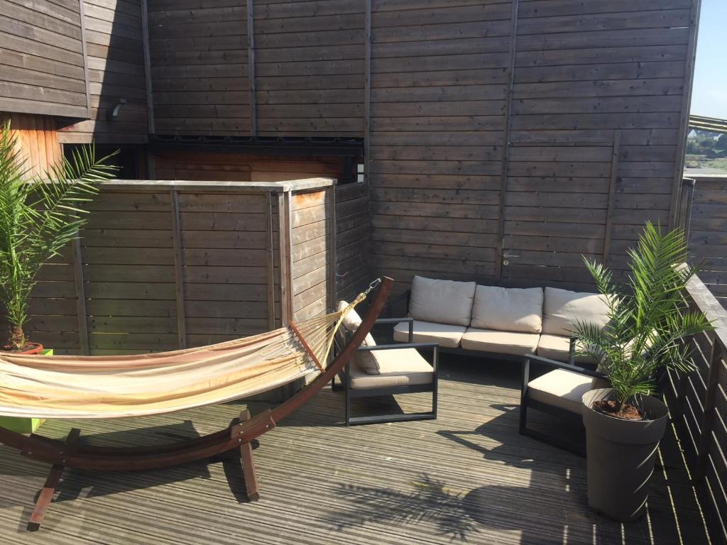 a hammock and a couch on a patio at Hôtel des Rochers in Perros-Guirec