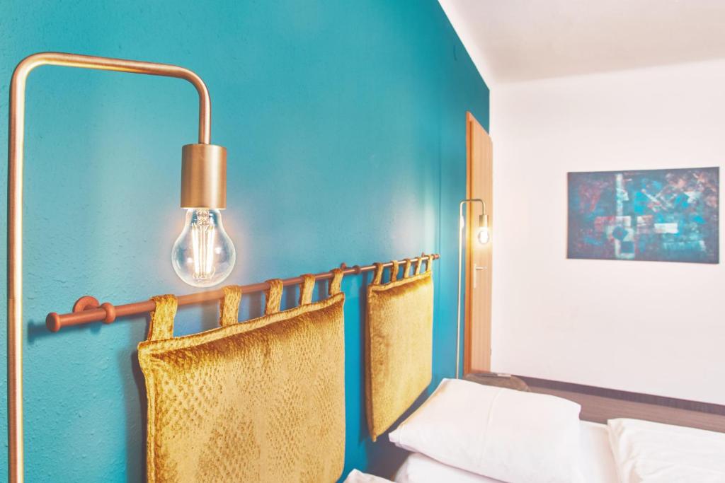 a room with a blue wall with a lamp and a couch at Boutique-Gasthof Ueberfuhr in Salzburg