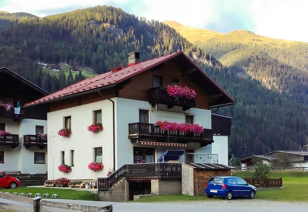 a house with flowers on the balconies of it at Haus Johanna in Sankt Jakob in Defereggen