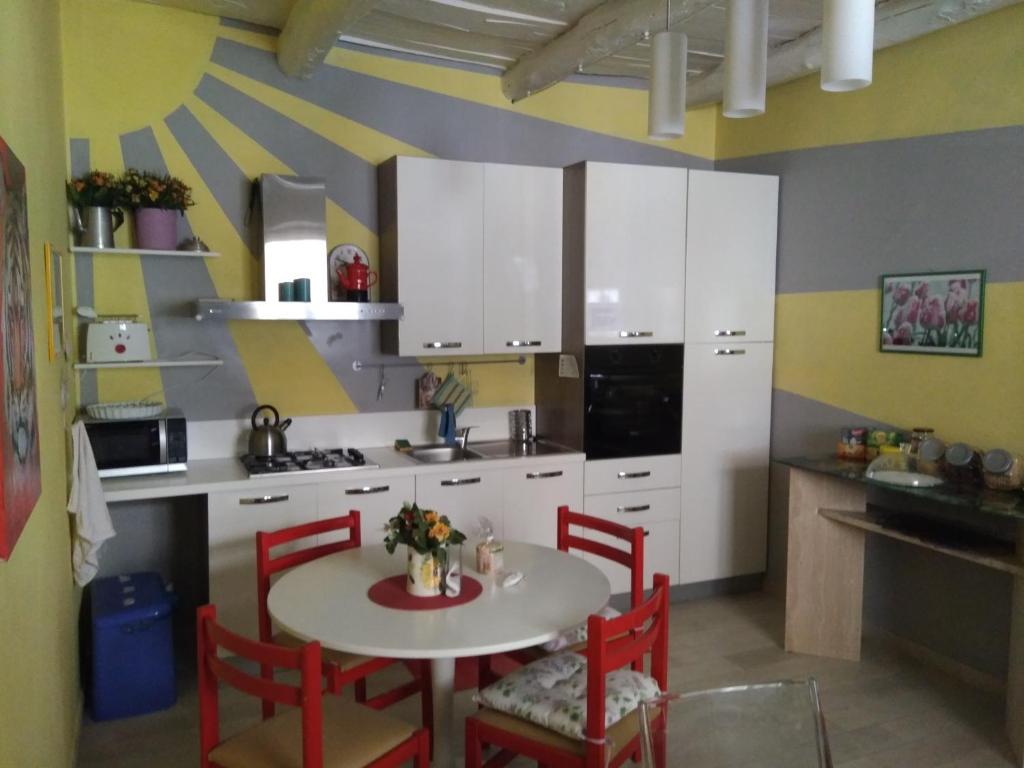 a kitchen with a table and red chairs in a room at B&B Parva Domus in Lamezia Terme