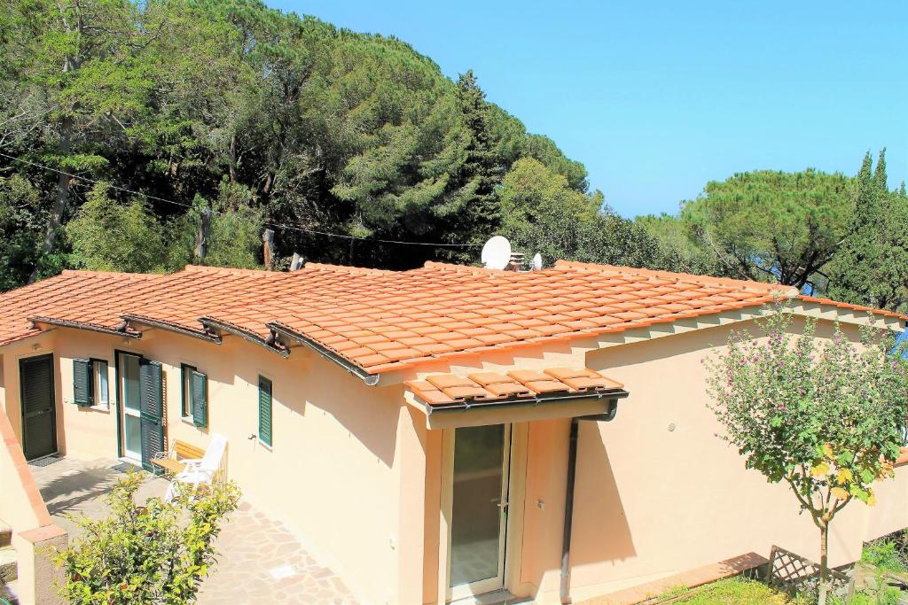 a house with a tiled roof and trees at Le Sprizze Mare in Marciana Marina