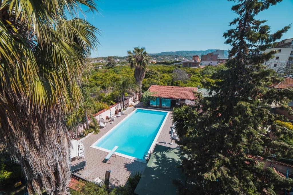 an overhead view of a swimming pool in a villa with palm trees at All'Ombra Del Noce B&B in Catona