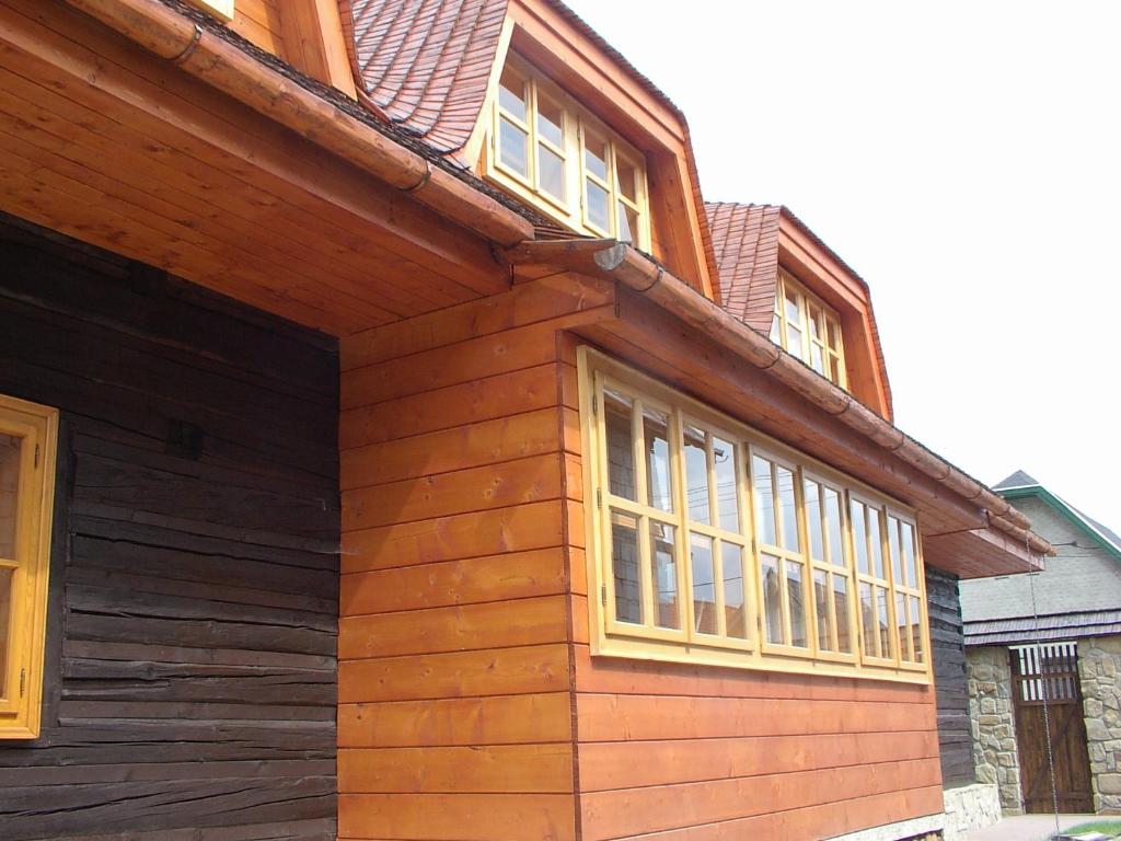 a wooden house with windows on the side of it at Drevenica u Starona in Liptovská Kokava
