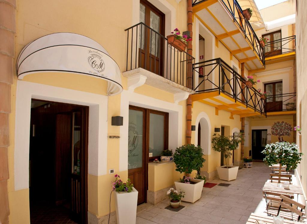 una fachada de un edificio con escaleras y macetas en Residence Cortile Mercè, en Trapani