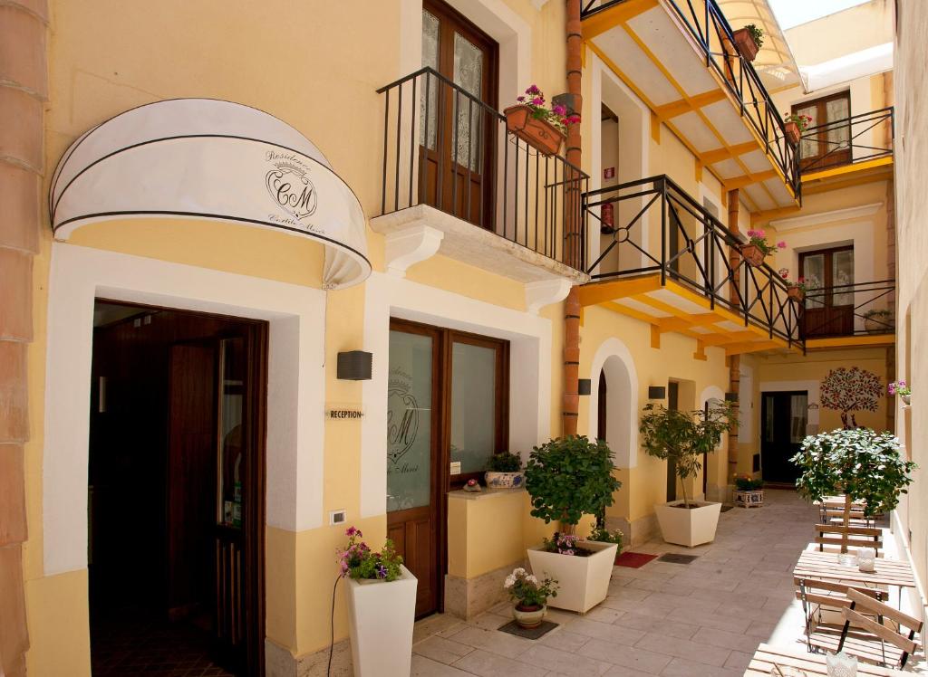 a facade of a building with stairs and potted plants at Residence Cortile Mercè in Trapani