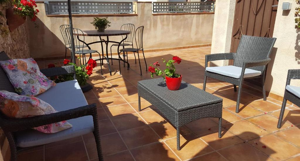 un patio con sillas, mesas y una mesa con flores en Casa Llebra II, en Roquetes