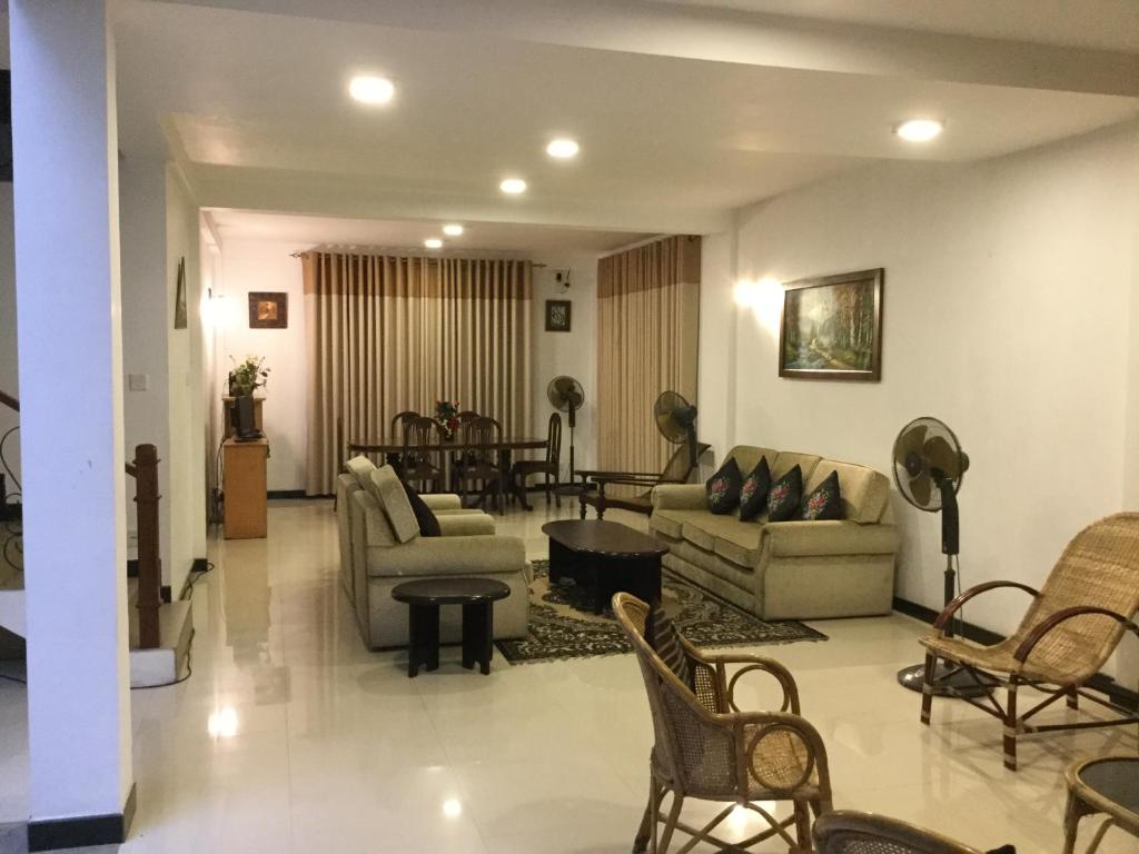 sala de estar con sofás, sillas y mesa en Avondale Colombo, en Maharagama