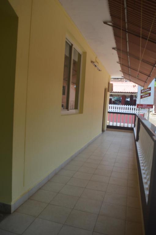 an empty corridor of a building with a window at James Guesthouse in Bogmalo