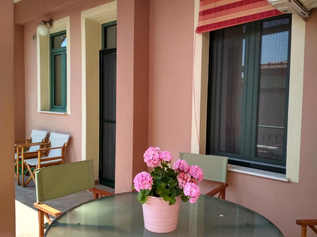 卡瓦拉的住宿－Sofokleous Apartment，玻璃桌边的花瓶,上面有粉红色的花朵