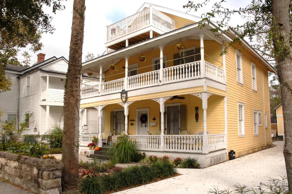 a large yellow house with a white balcony at Victorian Luxury One Bedroom Apartment in St. Augustine