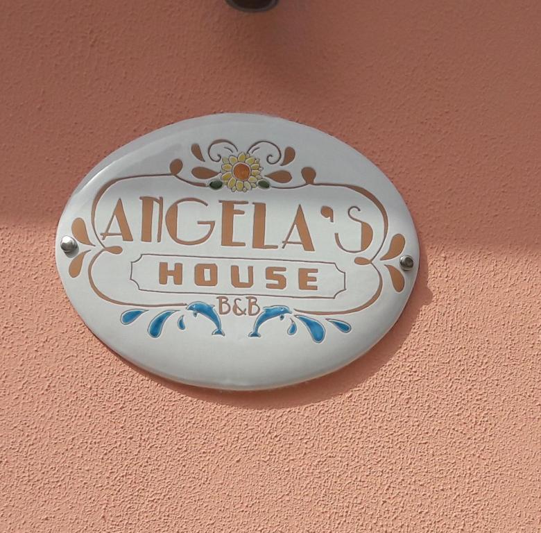Un cartello su un muro con sopra una casa di Aania. di Angela's House a Taranto