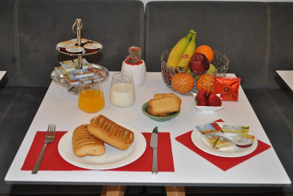 a table topped with plates of food and fruit at Prime Hotel in Tirana