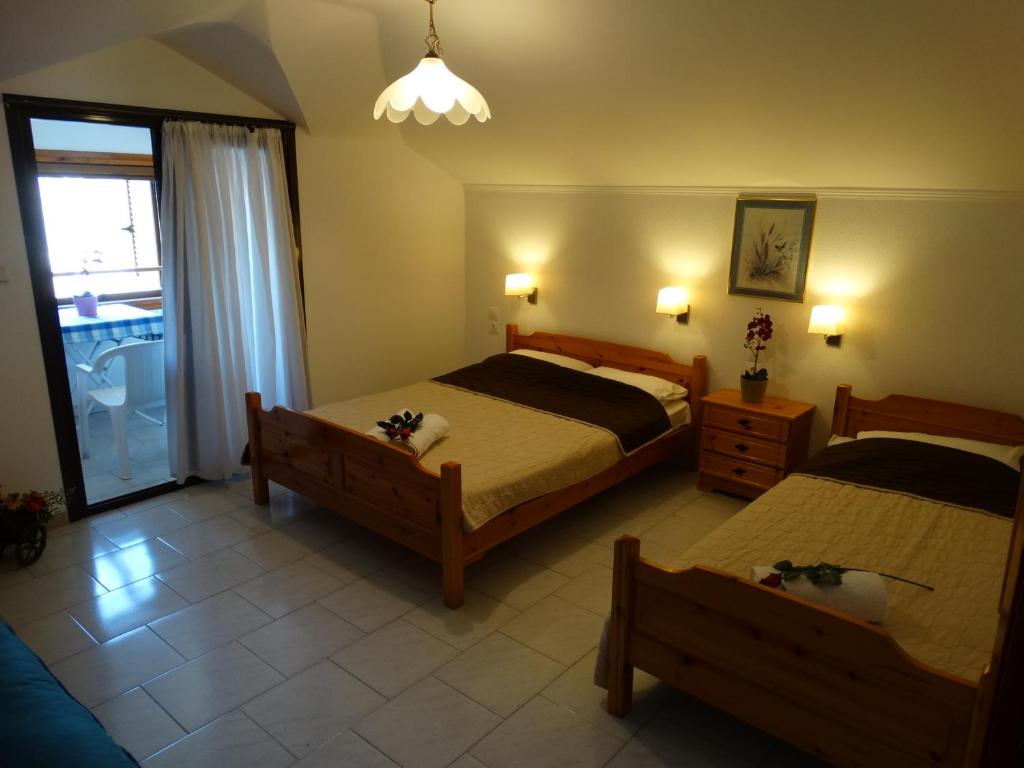 1 dormitorio con 2 camas y ventana en Christakos Apartments en Nea Vrasna