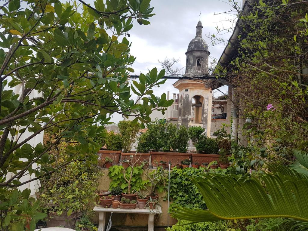 una casa antigua con un jardín con plantas en La Terrazza dei Pelargoni B&B en Ventimiglia