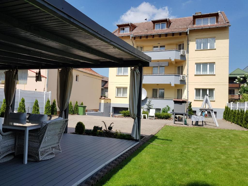 a wooden deck with a pergola in front of a building at Kiem Premium Apartments in Braşov