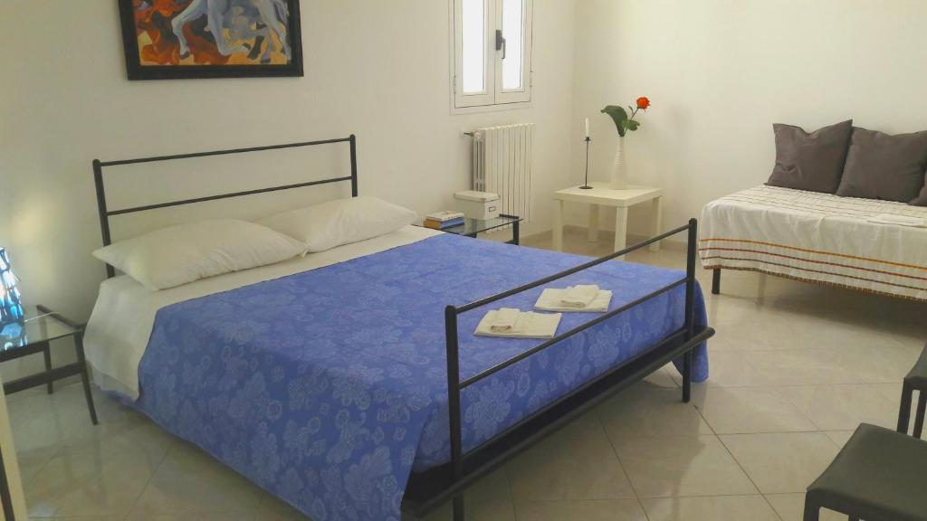 トッレ・デル・オルソにあるVilla Sole e Saleのベッドルーム1室(青い掛け布団付きのベッド1台付)