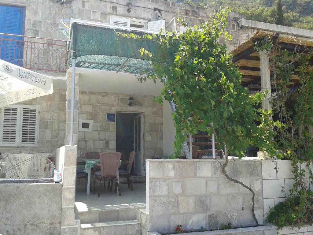 a small house with a table and a tree at Sunny Apartment Octopus in Prožura