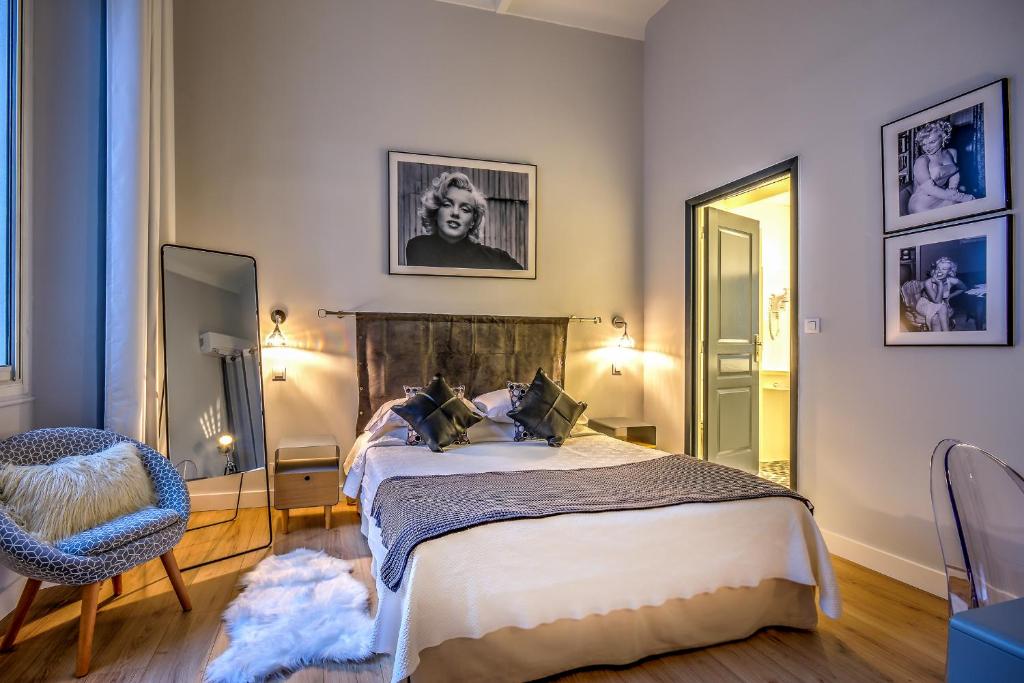 - une chambre avec un lit, une chaise et un miroir dans l'établissement Villa Claudia Hotel Cannes Centre - Parking, à Cannes