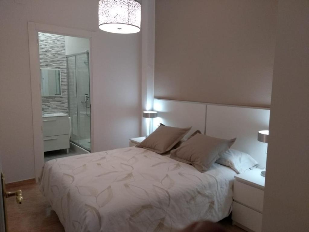 a bedroom with a white bed with two pillows at Piso céntrico Plaza Toros in Valencia