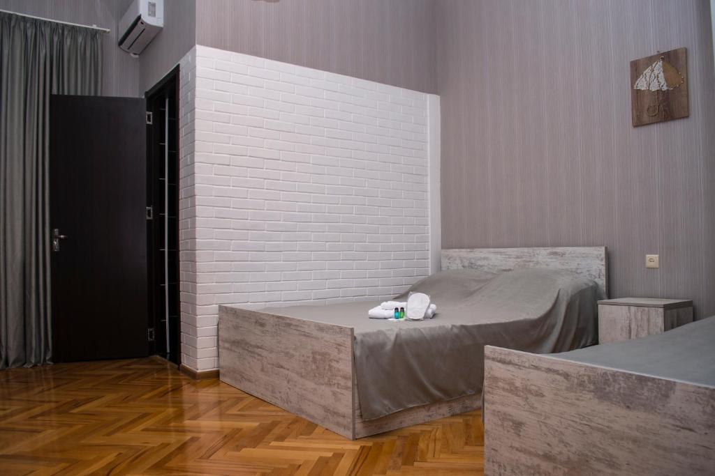 ein Schlafzimmer mit einem Bett und einer Ziegelwand in der Unterkunft Hotel Classic in Telawi