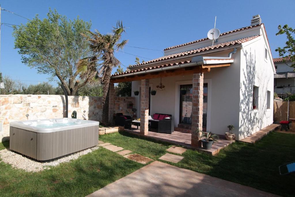 a small house with a hot tub in the yard at Villa Aurora in Loborika