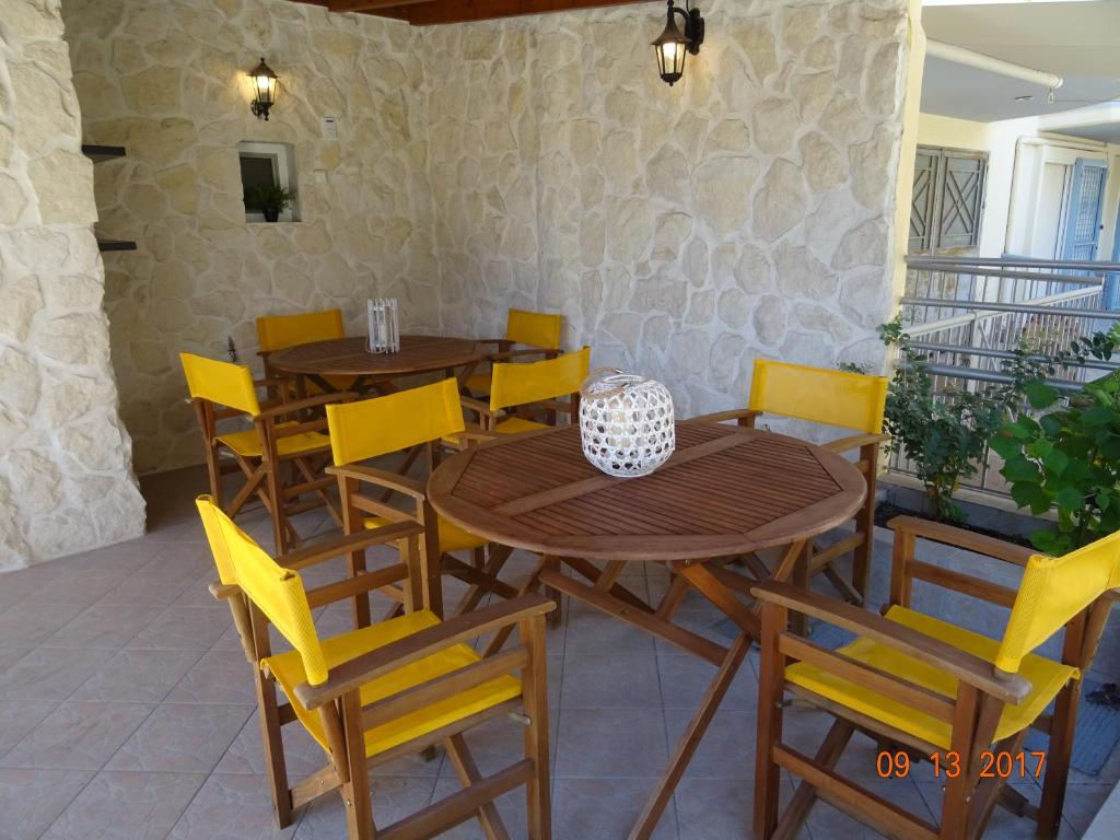 ein Esszimmer mit Holztischen und gelben Stühlen in der Unterkunft Paralia in Flogita